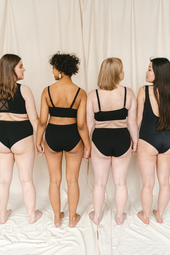 Diverse group of women in swimwear promoting body positivity and diversity.